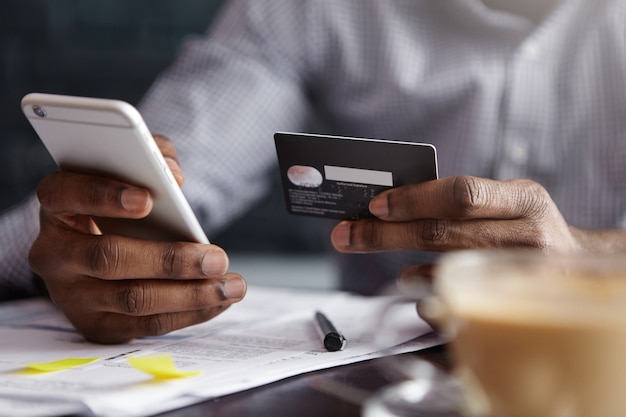 Cropped shot of African-American businessman paying with credit card online