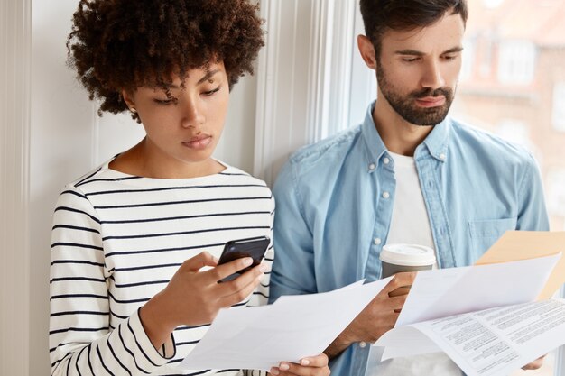 Cropped shot of interracial colleagues discuss statistics financial options