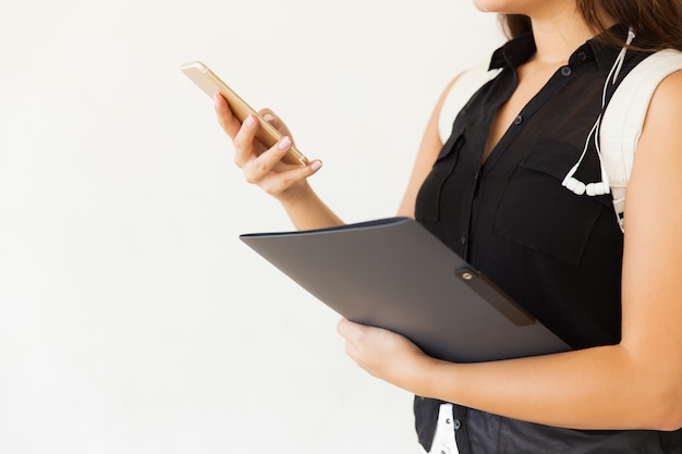 Cropped shot of student with folder and smartphone