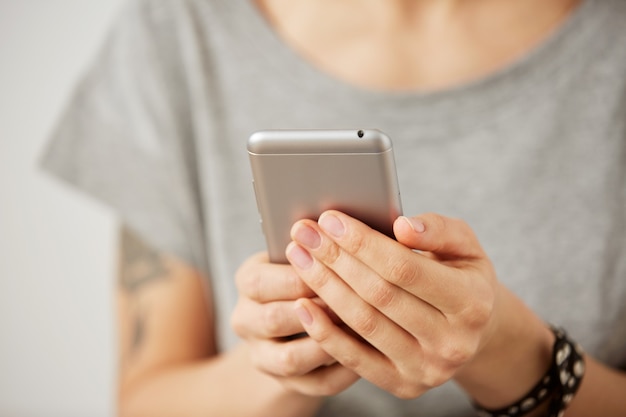 Free photo cropped shot view of a woman's hands holding mobile phone