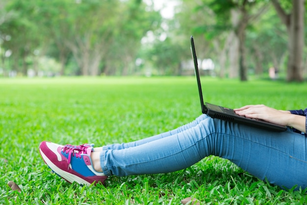 Cropped View of Girl Sitting on Grass With Laptop