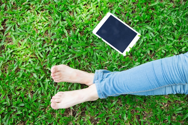 Cropped View of Girl and Tablet on Grass