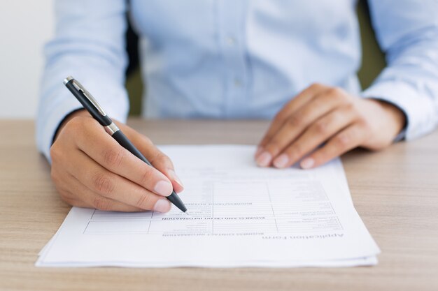 Cropped View of Person Completing Application Form