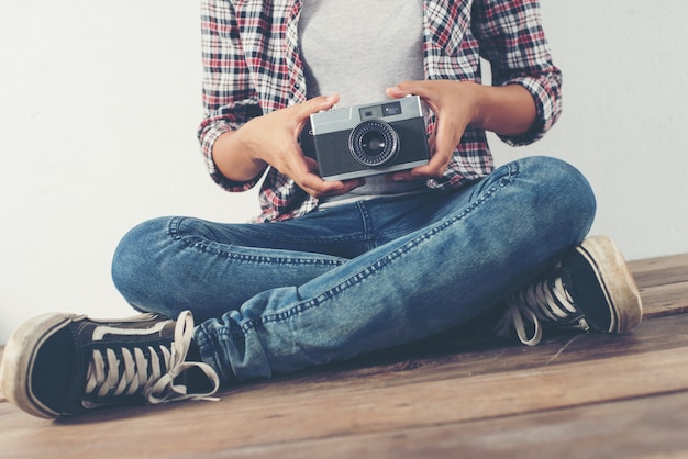 Free photo cross-legged girl with an old camera