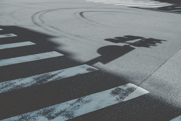 Crosswalk next to street sign shadow