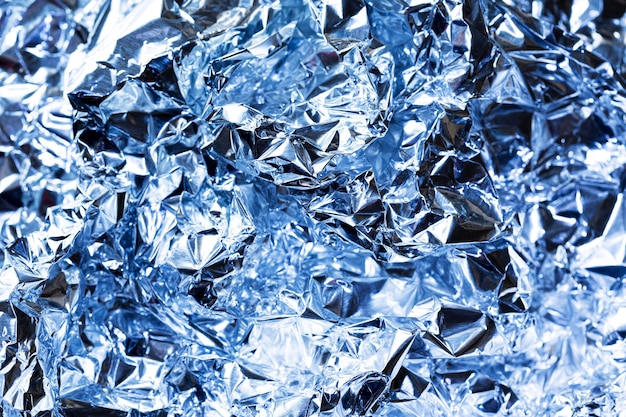 Free photo crumpled blue aluminium foil background