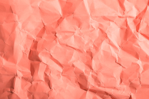 Free photo crumpled paper texture on coral background