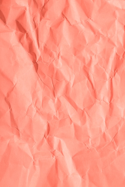 Free photo crumpled paper texture on coral background