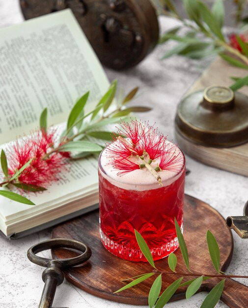 crystal glass of red cocktail garnished with flower