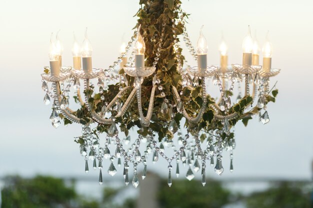 Crystals hang from the chandelier decorated with greenery