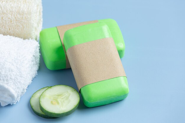 Cucumber slices and soap on light blue background