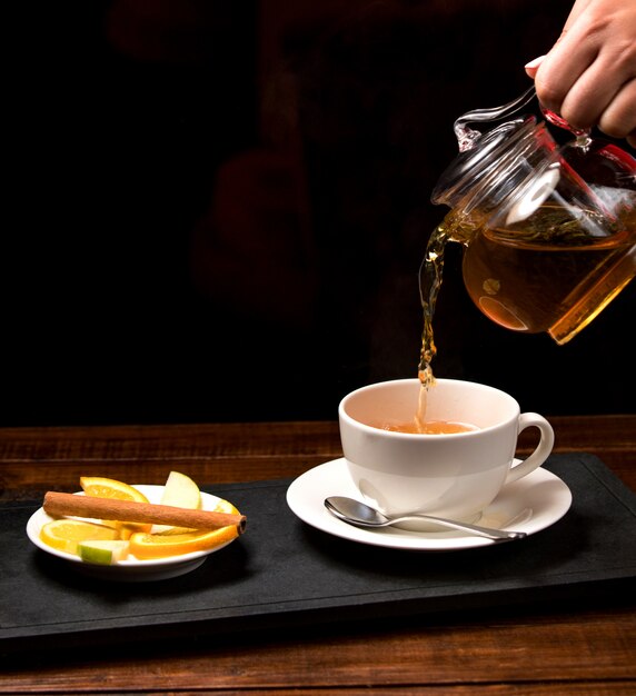 Cup of aromatic tea and bowl with lemon