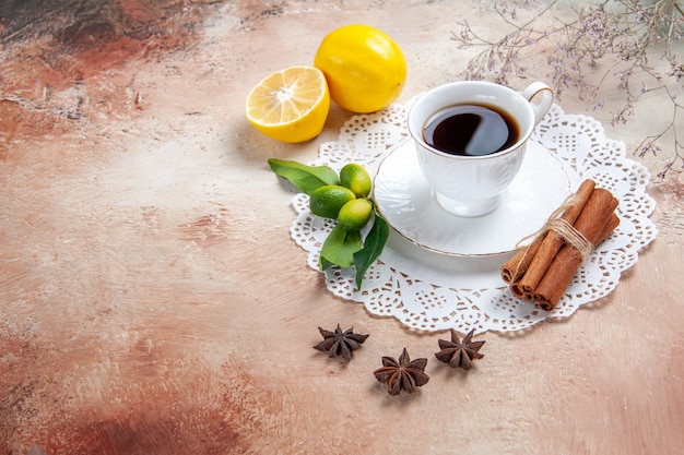 A cup of black tea on a white decorated napkin