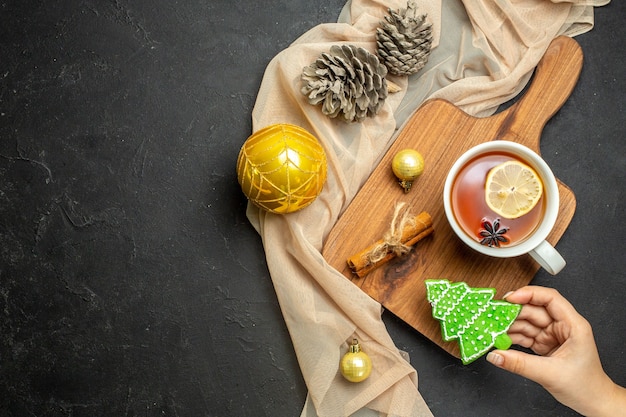 cup of black tea with lemon and cinnamon limes decoration accessories on wooden cutting board