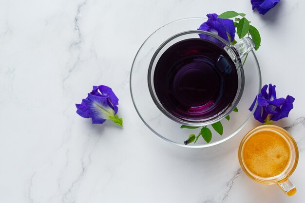 Cup of Butterfly pea flower tea with honey on table