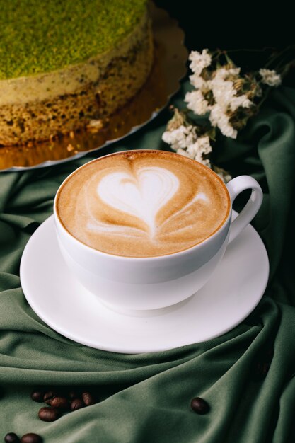 Cup of cappuccino and cake on the table