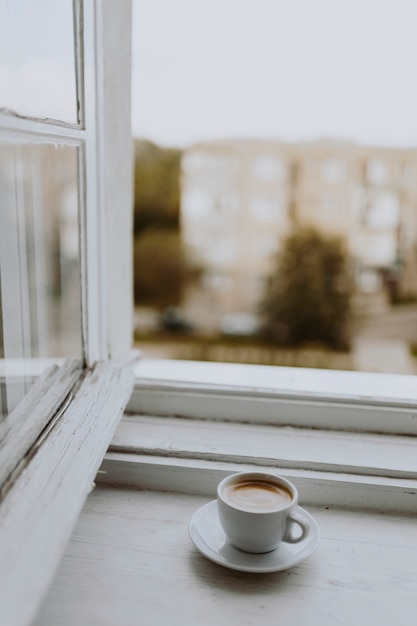 Free photo a cup of coffee by the window