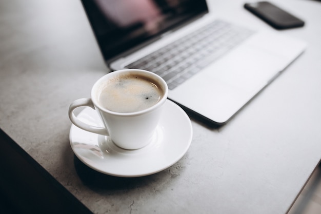 Free Photo cup of coffee and computer on table,top view