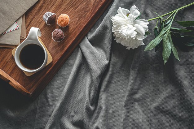 Cup of coffee and muffins on a tray in bed flat lay breakfast in bed