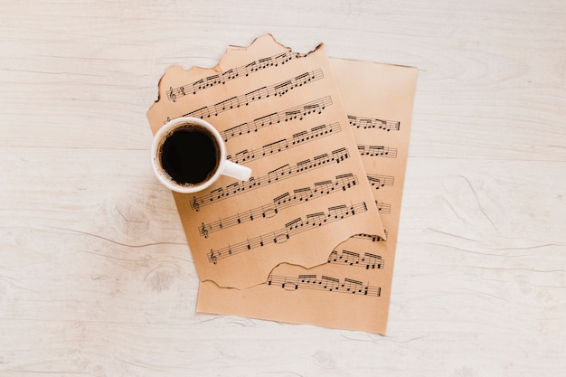 Free Photo cup of coffee near sheet music