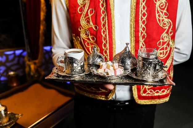 A cup of coffee served in ornated cups with lokums