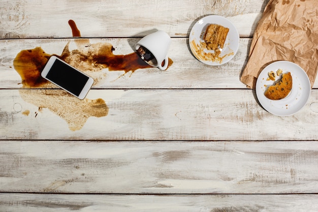 Cup of coffee spilled on wooden table