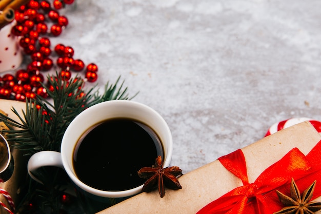 Free photo cup of coffee stands in the circle made of different kinds of christmas decor