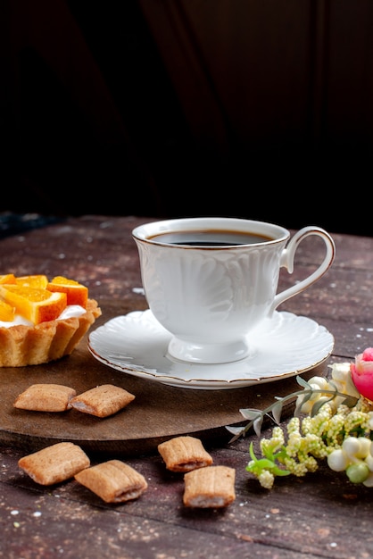 cup of coffee strong and hot along with cookies and orange cake on wooden desk, fruit bake coffee biscuit