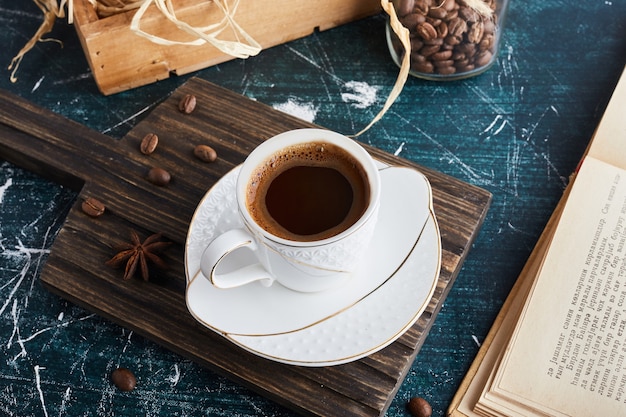 A cup of coffee in a white saucer.