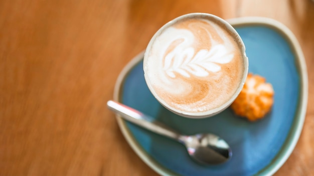 Free Photo cup of coffee with beautiful latte art on wooden table