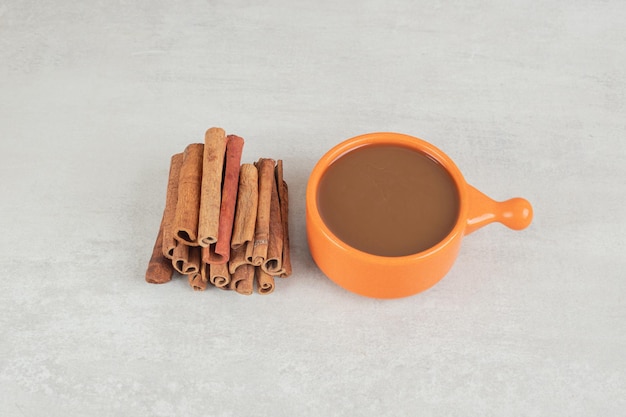 Free Photo cup of coffee with cinnamon stick on marble surface. 