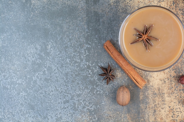 Free photo cup of coffee with cinnamon sticks on marble background. high quality photo