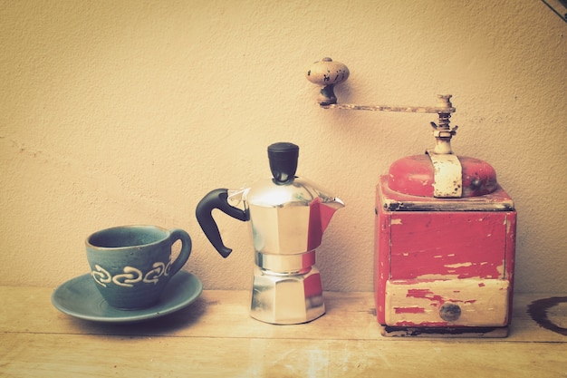 Free photo cup of coffee with a coffee pot and a grinder