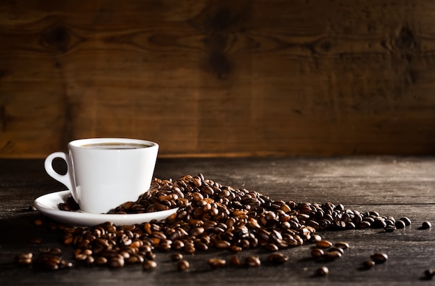 Cup of coffee with a pile of coffee beans