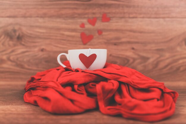 Cup of coffee with a red heart on a scarf