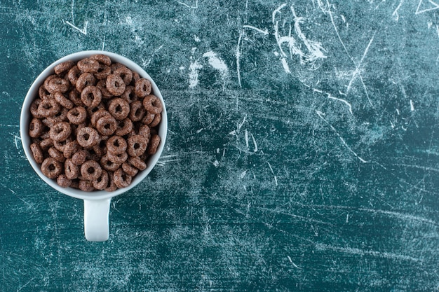 Free Photo a cup of corn rings , on the blue background. high quality photo