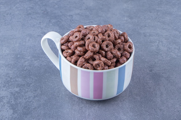 A cup of corn rings , on the blue background.