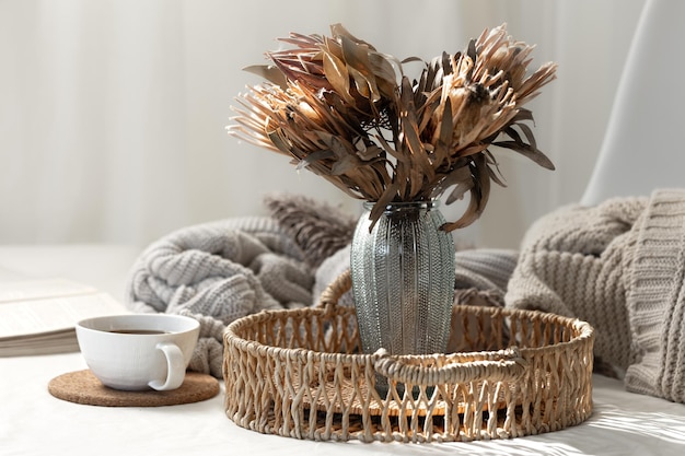 Free photo cup and dried flowers in a vase in the home interior of the living room