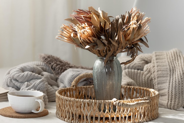 Free photo cup and dried flowers in a vase in the home interior of the living room