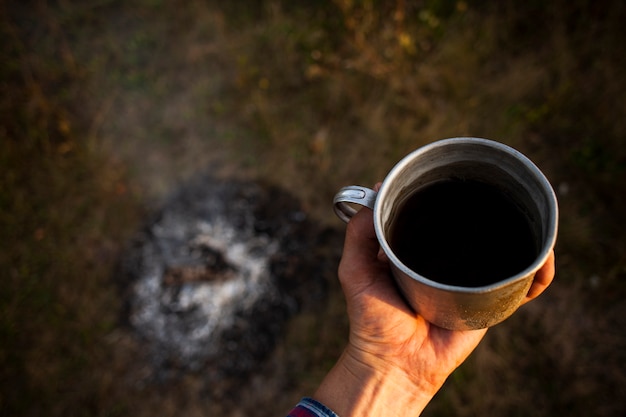 Cup of fresh coffee prepared while camping