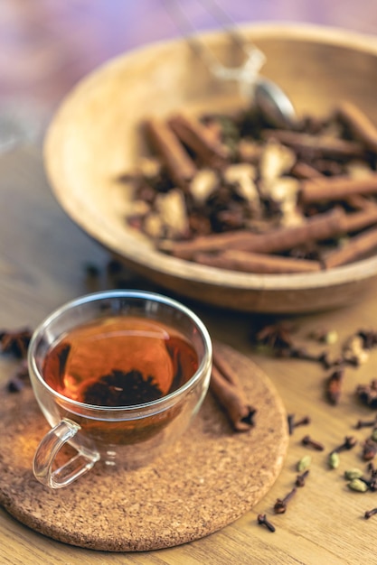 Free Photo cup of freshly brewed black tea different types of spices on wooden table