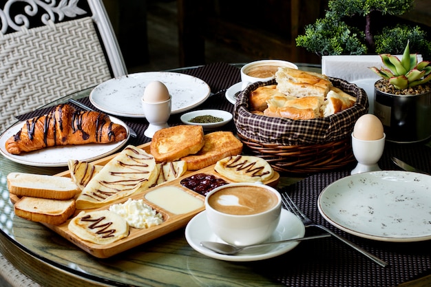 Cup of hot cappuccino and chocolate croissant with breakfast