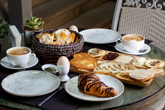 Cup of hot cappuccino and chocolate croissant with breakfast