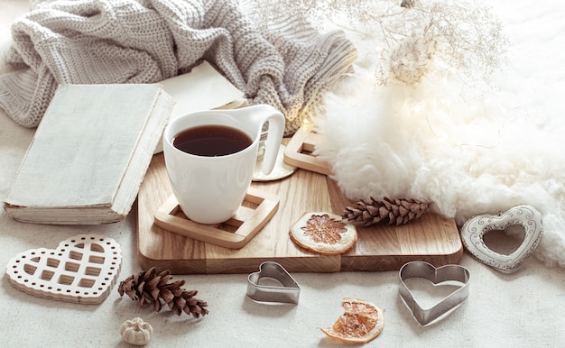 A cup of hot drink and cute home decor items. The concept of home comfort and aesthetics.