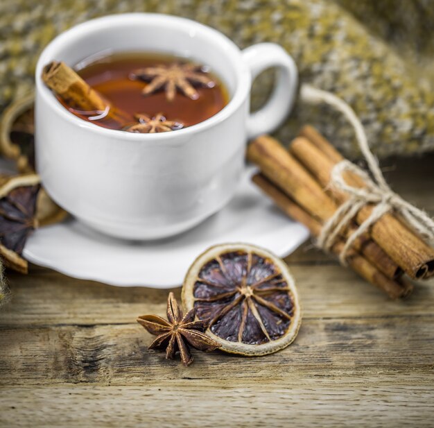 Cup of hot tea with cinnamon sticks and delicious dried citrus fruit