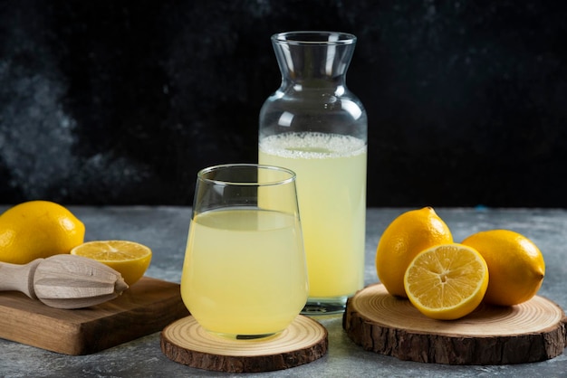 A cup of lemon juice on wooden board.