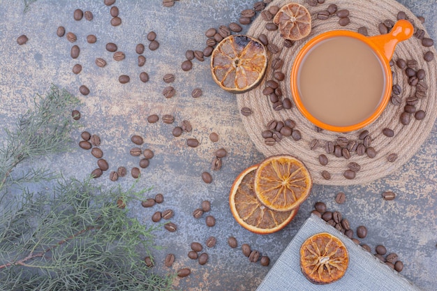 Cup of milk coffee with coffee beans and oranges. High quality photo