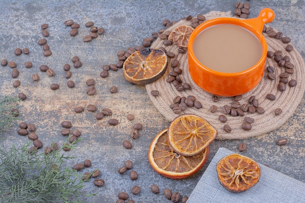 Cup of milk coffee with coffee beans and oranges. High quality photo