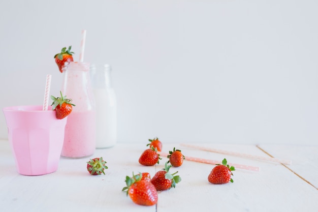 Free photo cup near bottles and strawberries