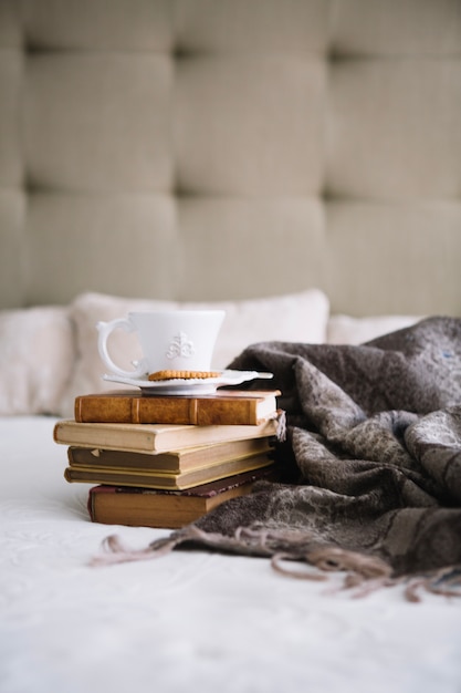 Free Photo cup on old books near blanket